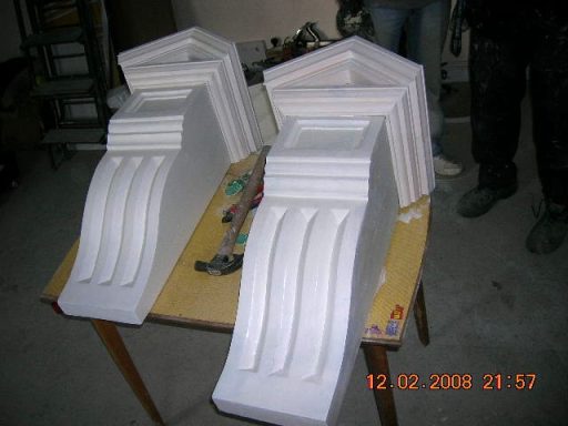White architectural mouldings displayed on a table.